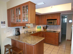 There are granite counters and wood cabinetry