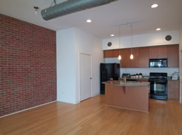 Loft style with a brick wall & exposed ductwork.
