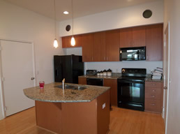 Kitchen features granite counters and wood cabinetry.